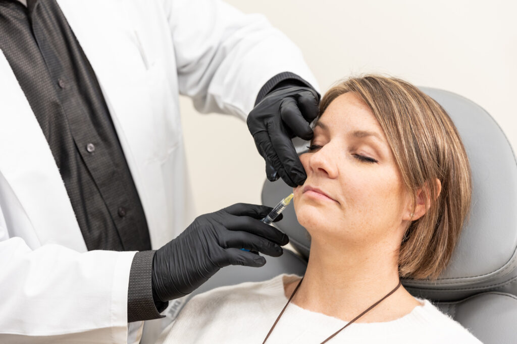 A female patient receives lip fillers near Blaine from a physician.
